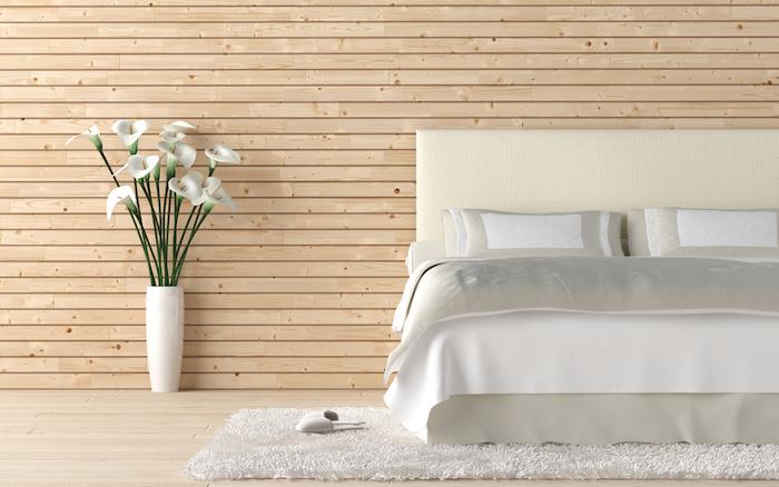 Six Bedroom Interior Tips To Provide Your Bedroom With A Larger Outlook. Interior design of wooden bedroom with bed and a vas of calla lilly flowers